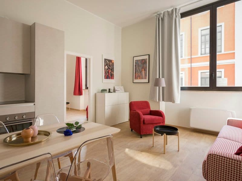 Compact apartment living and dining area with tall windows