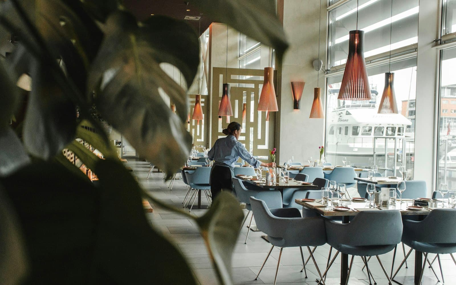 Restaurant dining room with copper pendants, glazing and foliage