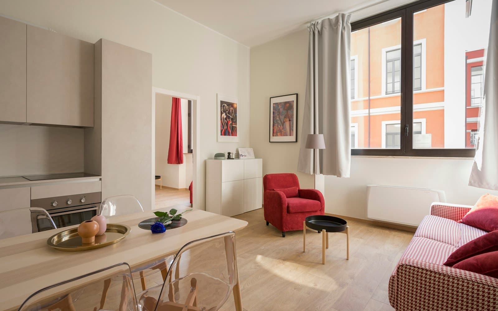 Compact apartment living and dining area with tall windows