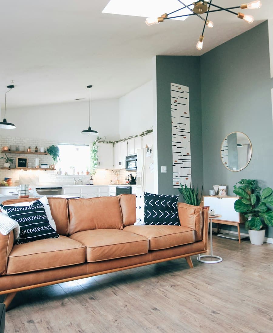 Tan leather sofa in a bright, plant-filled living room