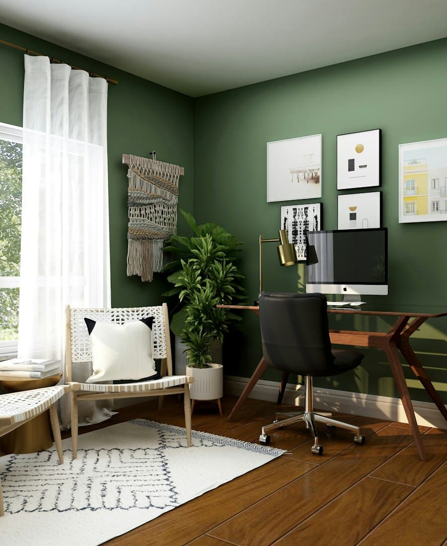 Green-walled home studio with a desk and framed prints
